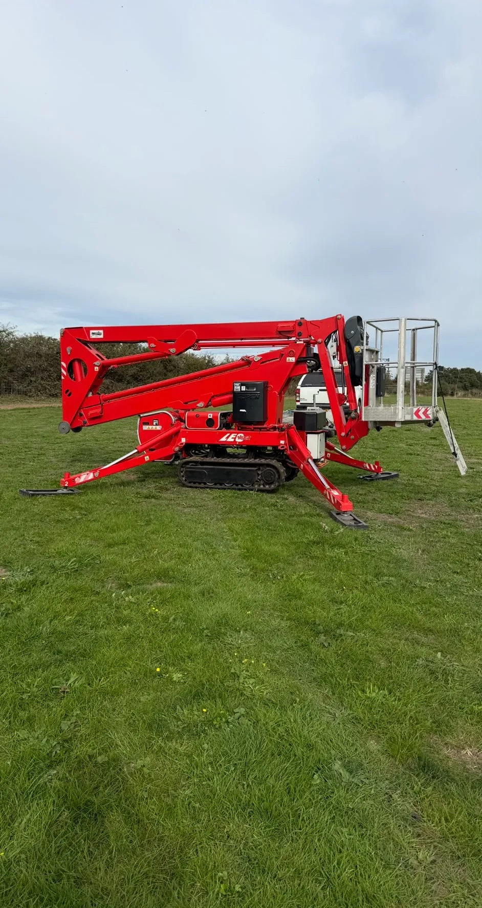 Compact tracked cherry picker set up on grass ready for high access work in Newark