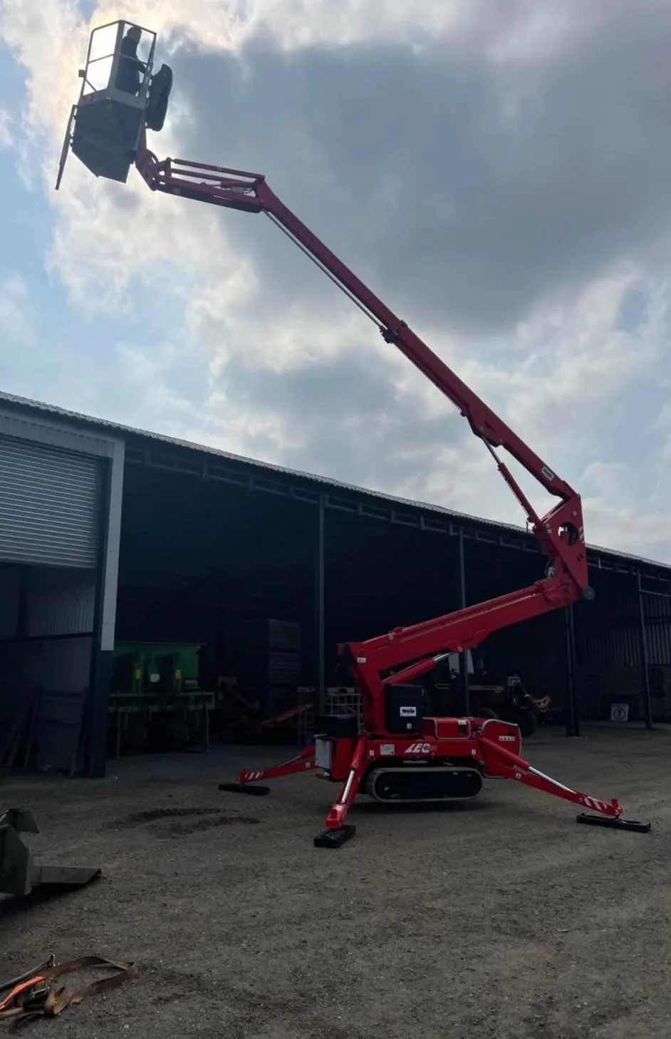 Operated cherry picker hire: tracked cherry picker with boom raised at an industrial building in Nottinghamshire